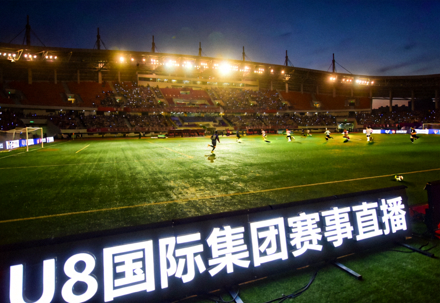 夜晚灯光下的足球场全景，U8国际集团赛事直播画面